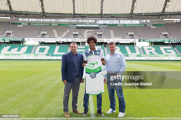 Klaus Allofs, Dante and Head Coach Dieter Hecking pose for photos on the pitch during a press conference at Volkswagen Arena on September 1, 2015 in...