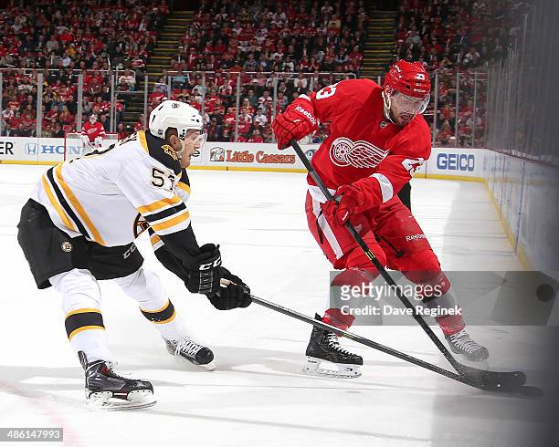 Justin Florek of the Boston Bruins and Brian Lashoff of the Detroit Red Wings battle for the puck along the boards during Game Three of the First...