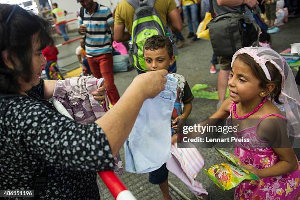 Volunteer hands over clothes to migrant children who had arrived at Munich Hauptbahnhof main railway station on September 1, 2015 in Munich, Germany....