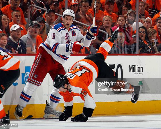 Dan Girardi of the New York Rangers hits Jesper Fast of the New York Rangers during the first period in Game Three of the First Round of the 2014 NHL...