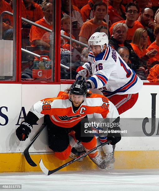 Claude Giroux of the Philadelphia Flyers is checked by Derick Brassard of the New York Rangers during the first period in Game Three of the First...