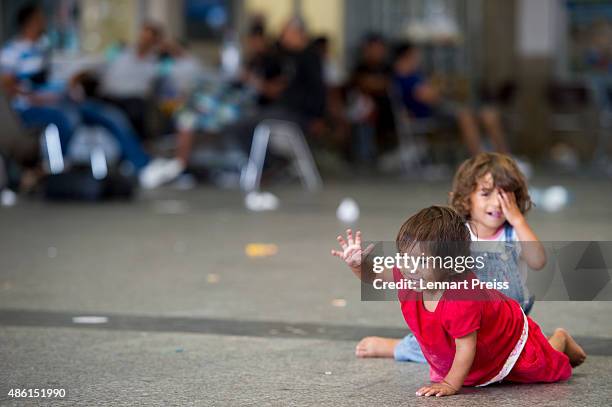 Two migrant girls play on the floor of a holding area after being detained by Police at Munich Hauptbahnhof main railway station and who had no...