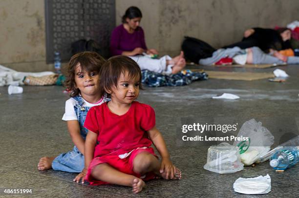 Two migrant girls play on the floor of a holding area after being detained by Police at Munich Hauptbahnhof main railway station and who had no...