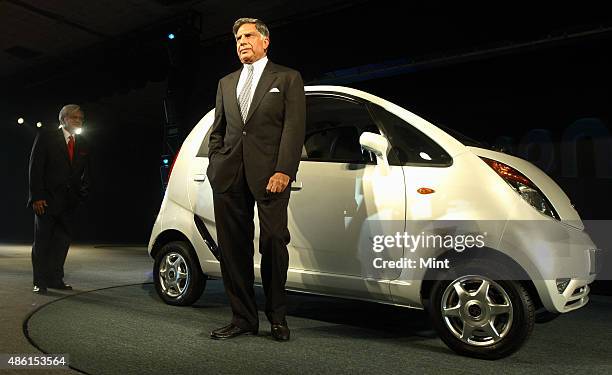 Tata Company Chairman Ratan Tata poses with the newly announced Tata Nano at the 9th Auto Expo on January 10, 2008 in New Delhi, India.