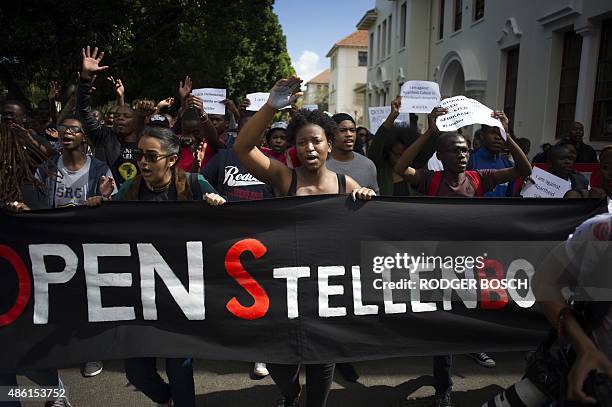 Students hold a banner reading "Open Stellenbosch" during a protest against allegations of rasicism on campus brought to light by a documentary...