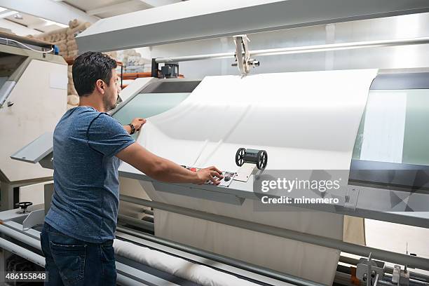 textile quality controller checking fabrics - textielfabriek stockfoto's en -beelden