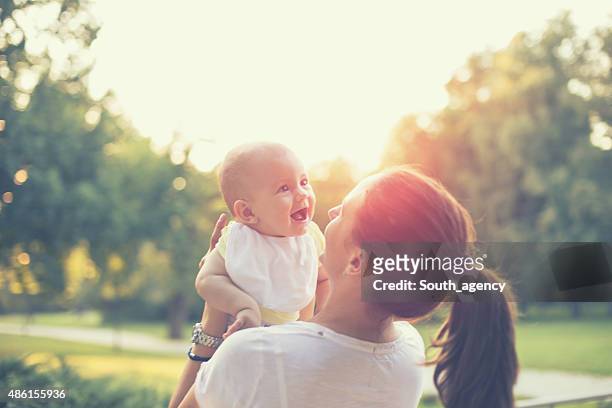 mother with baby in the park - baby nature stock pictures, royalty-free photos & images