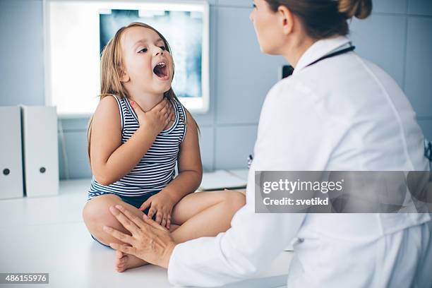 cute girl at doctor's office. - throat pain stock pictures, royalty-free photos & images