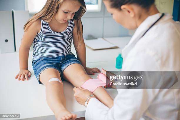 niedliche mädchen in arzt-büro. - wundverband stock-fotos und bilder