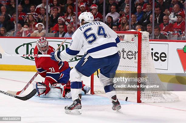 The puck gets by Carey Price of the Montreal Canadiens for s third-period goal as Cedric Paquette of the Tampa Bay Lightning looks on in Game Four of...