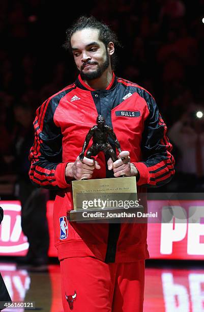 Joakim Noah of the Chicago Bulls smiles as he accepts the 2013-1014 NBA Defensive Player of the Year trophy before Game Two of the Eastern Conference...