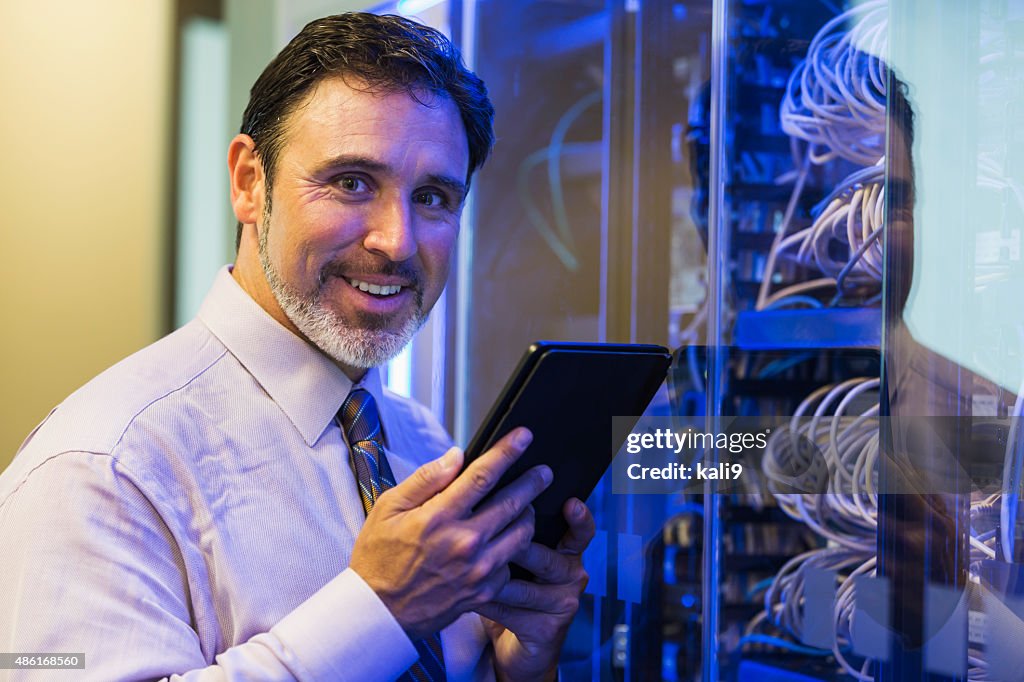 Man with digital tablet in server room