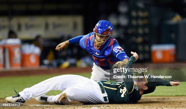 John Jaso of the Oakland Athletics is tagged out at home plate by Robinson Chirinos of the Texas Rangers in the bottom of the second inning at O.co...