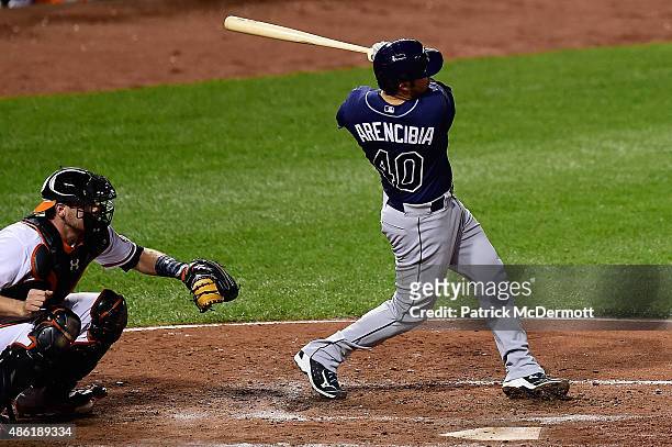 Arencibia of the Tampa Bay Rays hits a two-run RBI single in the fourth inning during a baseball game against the Baltimore Orioles at Oriole Park at...