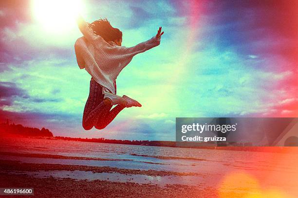 felice giovane donna di correre e saltare sulla spiaggia - self satisfaction foto e immagini stock