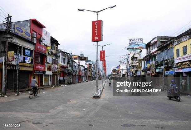 Indian commuters are seen on empty roads during a nationwide strike called by trade unions against the central government in Agartala on September 2,...