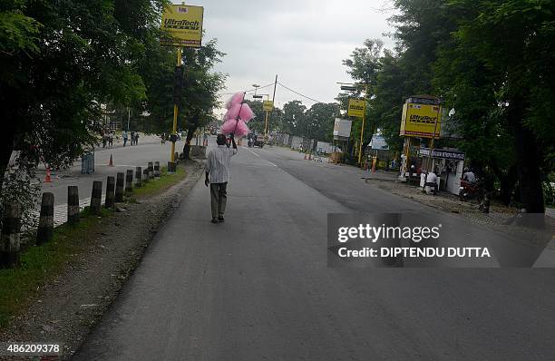 An Indian vendor walks along a deserted street during a nationwide strike called by trade unions against the central government's economic policies,...