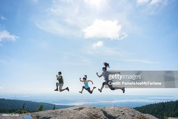 three people running and jumping on mountain top, cliff edge - 3 generations sport stock pictures, royalty-free photos & images