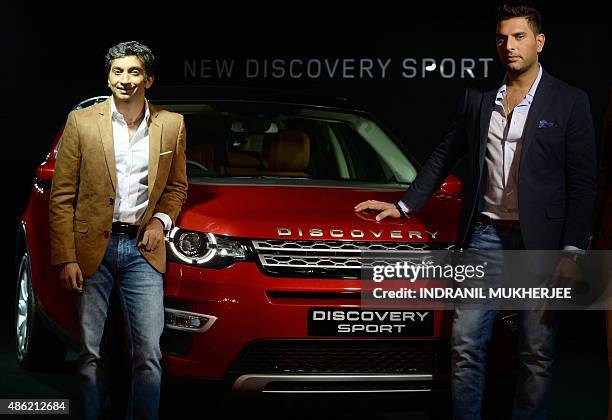 India's first Formula One race car driver Narain Karthikeyan and Indian cricketer Yuvraj Singh pose with the Land Rover Discovery Sport car at its...