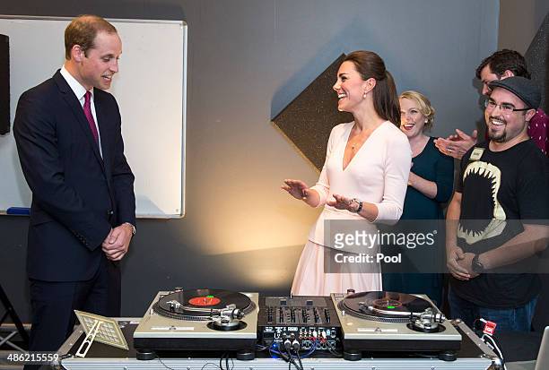 Catherine, Duchess of Cambridge and Prince William, Duke of Cambridge laugh as they are shown how to play on DJ decks at the youth community centre,...