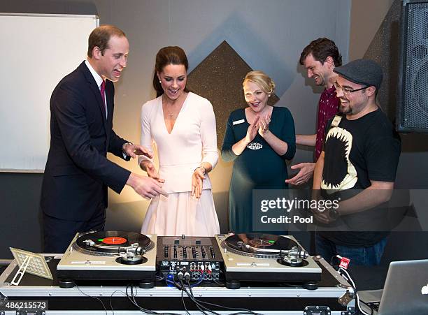 Catherine, Duchess of Cambridge and Prince William, Duke of Cambridge laugh as they are shown how to play on DJ decks at the youth community centre,...
