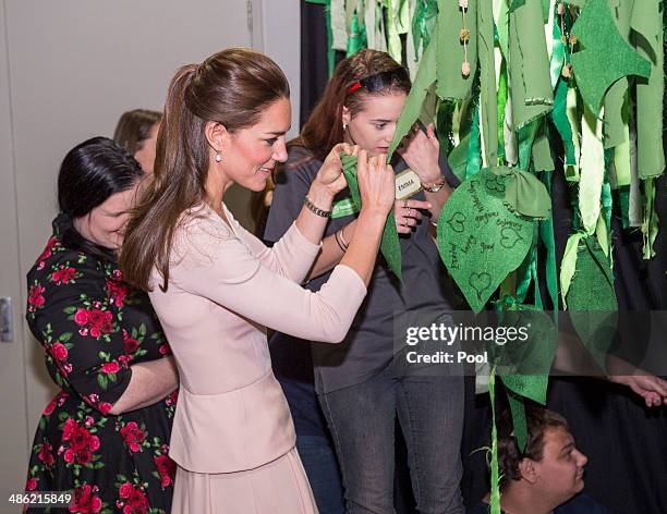 Catherine, Duchess of Cambridge ties on a leaf to the Mental Health Tree during her visit to the youth community centre, The Northern Sound System,...
