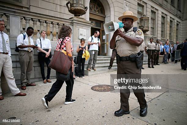 Baltimore City Sheriff's deputy gives instructions to journalists in front of the Baltimore City Circuit Courthouse East where pre-trial hearings...