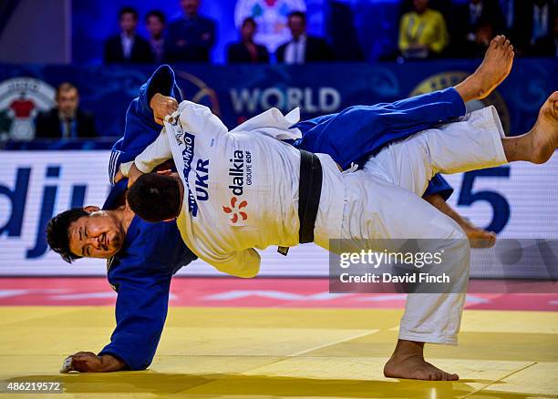 Iakiv Khammo of Ukraine heaves Sung-Min Kim of South Korea high into the air to throw him on his back for ippon and win the 100kg bronze medal during...