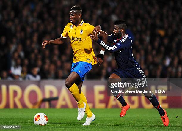 Paul Pogba of Juventus holds off Arnold Mvuemba of Olympique Lyonnais during the UEFA Europa League Quarter Final 1st leg match between Olympique...