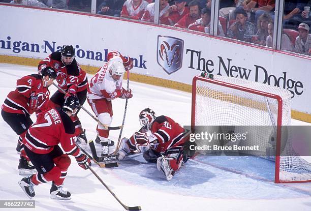 Goalie Martin Brodeur of the makes the save as his teammates Scott Stevens, Scott Niedermayer and Tom Chorske come to his aide as Ray Sheppard of the...