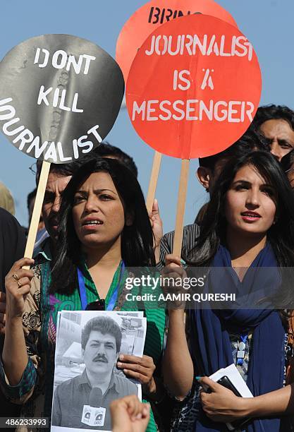 Pakistani journalists hold placards and photographs bearing the image of Geo television journalist Hamid Mir during a protest against the attack on...