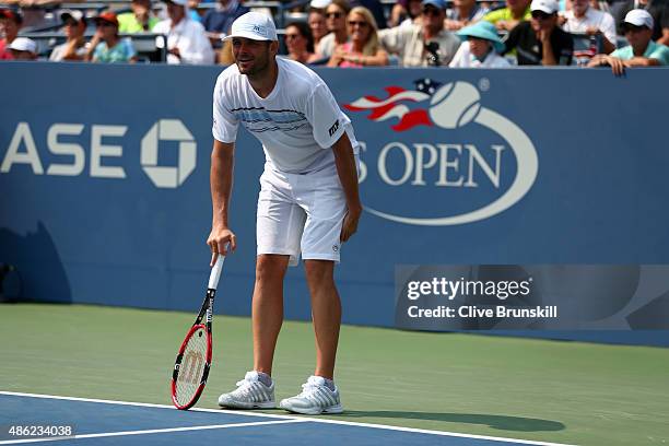 Mardy Fish of the United States holds his leg while playing against Feliciano Lopez of Spain during their Men's Singles Second Round match on Day...