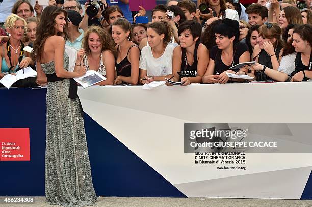 Festival hostess, Italian actress and model Elisa Sednaoui signs autographs as she arrives for the opening of the 72nd Venice International Film...