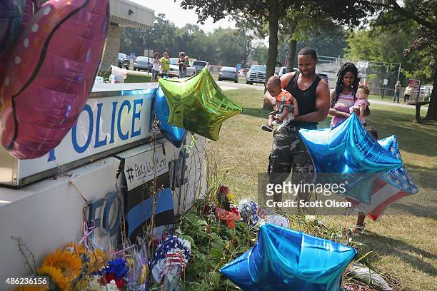Daniel Byrd and his sisiter Danielle and their children pay respects to Lt. Joe Gliniewicz at a makeshift memorial outside the Fox Lake Police...