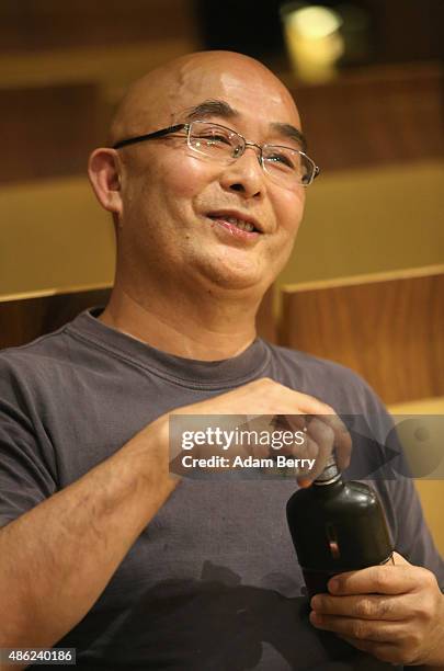 Chinese poet Liao Yiwu has a drink as he waits for the beginning of a panel discussion at the Berlin International Literature Festival on September...