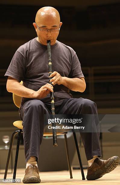 Chinese poet Liao Yiwu practices his xiao, or Chinese flute, as he waits for the beginning of a panel discussion at the Berlin International...