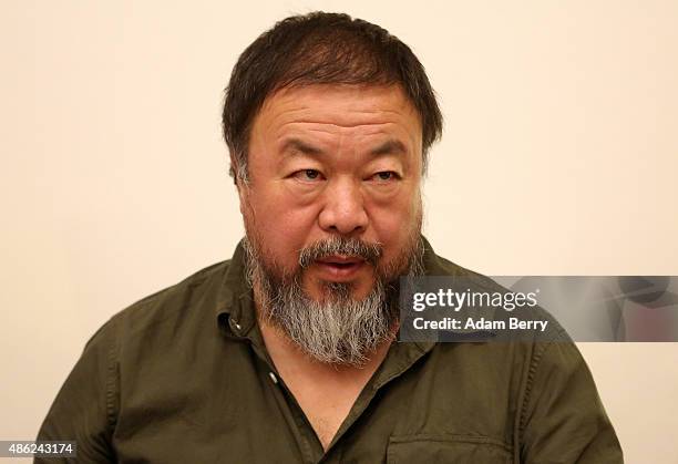 Chinese dissident artist Ai Weiwei pauses as he signs books for fans after a panel discussion at the Berlin International Literature Festival on...