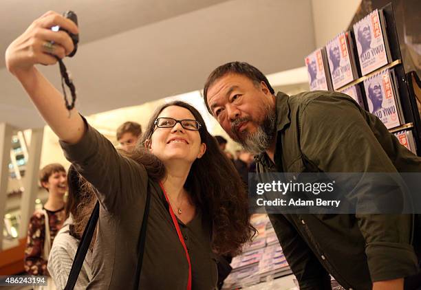 Chinese dissident artist Ai Weiwei poses for a selfie with fan Isabelle Spicer as he gives autographs after a panel discussion at the Berlin...