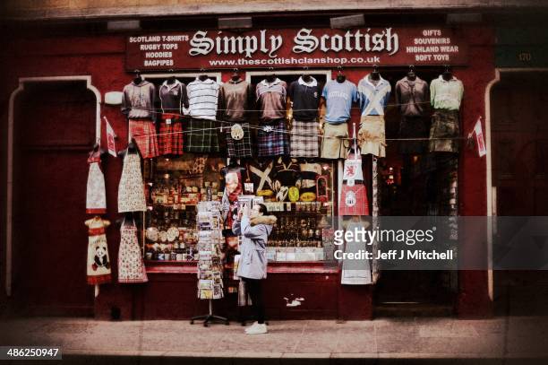 Woman stops to take a photograph outside a shop on the Royal Mile on April 23, 2014 in Edinburgh, Scotland. A referendum on whether Scotland should...