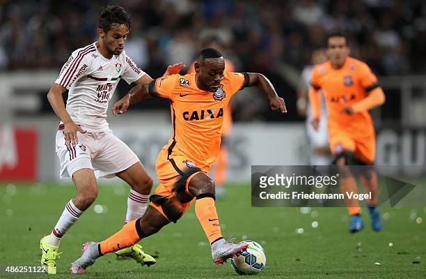 Vagner Love of Corinthians battles for the ball with Gustavo Scarpa of Fluminense during the match between Corinthians and Fluminense for the...