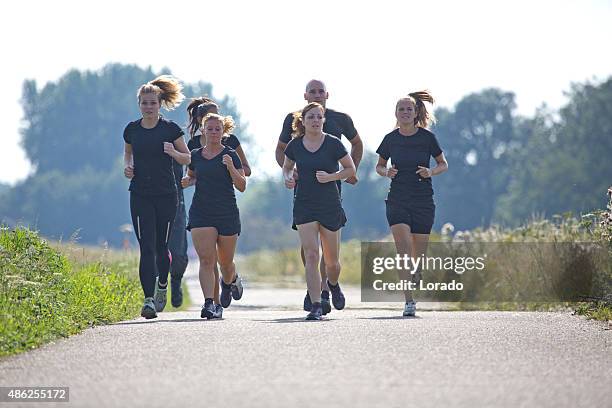 grupo de amigos trotar al aire libre - carreras de obstáculos prueba en pista fotografías e imágenes de stock