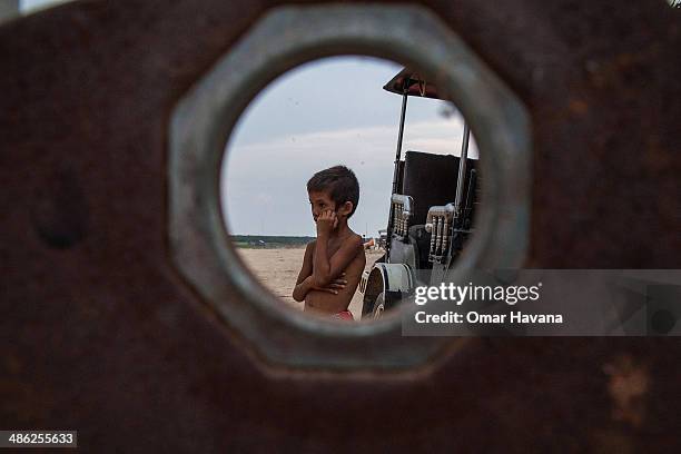 Young boy waits for the arrival of tourists near the floating village of Chong Kneas on April 23, 2014 in Siem Reap, Cambodia. Home to hundreds of...