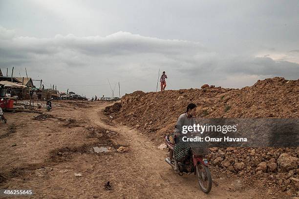 Resident of Chong Kneas drives a motorbike near the development area of a new tourist dock that forced residents to move inland on April 23, 2014 in...