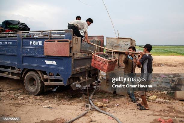 Group of young former fishermen carry fish boxes into a truck in the floating village of Chong Kneas on April 23, 2014 in Siem Reap, Cambodia. Most...