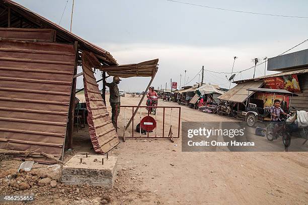 Young boy rides a bicycle near the checkpoint access to the village of Chong Kneas where tourists must pay USD3.00 to visit on April 23, 2014 in Siem...