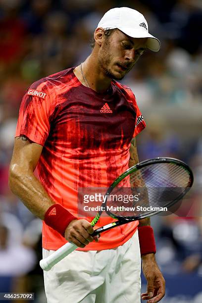 Andreas Haider-Maurer of Austria examines his racquet between points against Novak Djokovic of Serbia during their Men's Singles Second Round match...