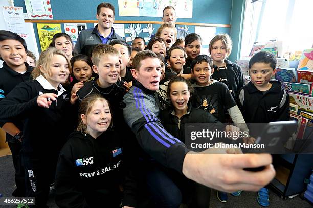 Colin Slade of the All Blacks takes a selfie with students during the All Black To The Nation visit to Mataura school on September 3, 2015 in...