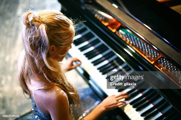 woman playing piano in a concert. - piano concert stock pictures, royalty-free photos & images