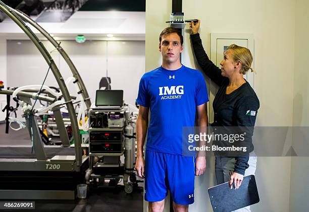 Santiago Ardila, a 19-year-old post-graduate student athlete from Mexico, left, has his height measured by a scientist at the Gatorade Sports Science...