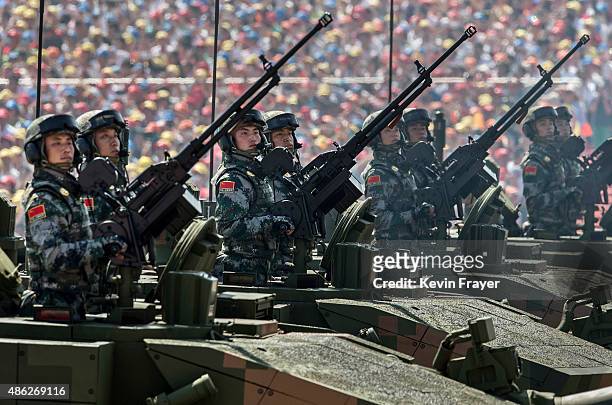 Chinese sldiers ride in an armoured vehicle as they pass in front of Tiananmen Square and the Forbidden City during a military parade on September 3,...